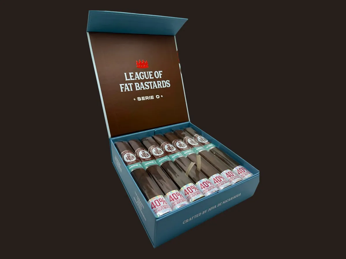 An open light blue League of Fat Bastards Serie O box of cigars with teal Serie O bands and foot bands reading 40%, printed Crafted by Joya de Nicaragua
